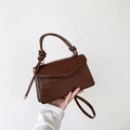 Dark coffee ruched leather handbag with knotted handle and v-shaped flap design - Brown
