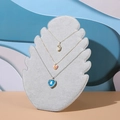 Grey velvet flame-shaped jewelry display stand showing multiple necklaces on a blue backdrop - 28*20cm / Gray
