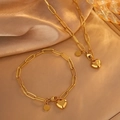 Goldenes Büroklammer-Ketten-Schmuckset mit Herzanhängern auf elegantem Seidenhintergrund - Set 1