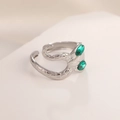 Macro shot of snake scale textured stainless steel ring with two green faceted gemstones - Steel Color Snake