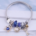 Silver twisted cable bracelet with blue heart bear charm and Prince engraved coin - Blue