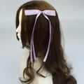 Elegant purple satin bow hair clip with long ribbons on dark wavy hair style - Light Purple