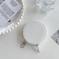 Macro shot of white round coin purse with lychee texture and silver hook on pearl tray - White