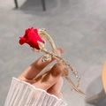 Close-up of elegant gold flower hair clip with a red rose and sparkling rhinestones - Red Matte Rose Flower Hair Clip