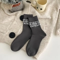 Charcoal grey Fair Isle socks with white snowflake pattern in a cozy winter setting - One Size / Grey Geometric