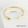 Detail van gouden slangenarmband met groene zirkoonogen en afmetingen van 6,05 cm - Stijl 1