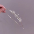 Close-up of golden metal headband featuring leaf-shaped crystal and rhinestone details - Tree Branch