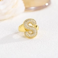 Dettaglio anello regolabile oro con lettera S in cristalli pavé dal design bombato - S