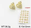 Detailed macro view of 18k gold plated copper heart earrings set with sparkling stones - Hollow Heart