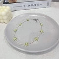 Close-up of white seed bead necklace with light green starfish pendants on a ceramic tray - Off-white Beads + Light Green Starfish Necklace