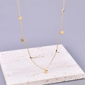 Collana minimalista in acciaio placcato oro 18K con piccoli ciondoli a stella su marmo - Oro 18K