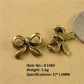 Detail of vintage bronze bow charm 17x14mm with coin for size reference and metal specs - A1460-17*14MM