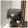 Détails macro d'un sac bandoulière en cuir matelassé noir avec fermoir en métal doré - Noir