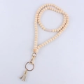 Detail of wooden bead lanyard with gold lobster clasp and beige leather tassel accent - Crown