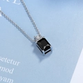 Detail of rectangular black gemstone pendant with a round white zircon accent on silver chain - Black Zirconia