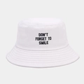 Detail van het zwarte borduurwerk 'DON'T FORGET TO SMILE' op een witte katoenen vissershoed - Verstelbaar / Wit