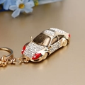 Sparkling gold car keychain with clear rhinestones and red accents on metallic chain - Rhinestone Luxury Car