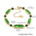 Detail of emerald glass stones and lobster clasp on a vintage style gold stainless bracelet - Green