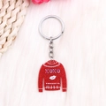 Détail d'un porte-clés pull rouge pailleté avec motif XOXO sur fond de fourrure - Pull Rouge Lèvres