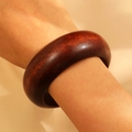 Macro detail of wide dark sandalwood bangle showing natural wood grain on wrist - 3cm Wide Style (01 Brown 2163) / Brown