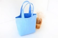 Detail view of a bright blue canvas lunch bag with dual handles and minimalist design - Light Blue (Open)
