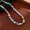Macro shot of baroque pearl and aquamarine beaded necklace with gold textured spacers - Necklace / Blue