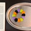 Handmade wool felt ball keychain with purple, black, orange, and lime green accents - Dark Sweet Bean Chain