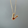 Macro shot of a polished gold letter V pendant on a delicate O-chain necklace - Letter V Single Pendant