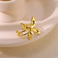 Detail of gold-plated butterfly open ring with hollow wings on beige ceramic - Butterfly