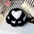Detail of soft black and white plush cat paw keychain with a large heart pattern detail - Black
