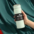 Muntgroene 304 roestvrijstalen vacuümgeïsoleerde sportwaterfles in de hand gehouden. - 500ml / Slim Groen (LED-deksel)