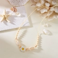 Detail der gewebten Strandkette mit natürlichen Muscheln, Holzperlen und Frangipani-Blume - Weiß