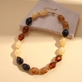 Detail of retro acrylic oval beaded necklace with amber and black stones on stone decor - Necklace-Coffee