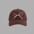 Close-up of white bow embroidery on a dark brown cotton canvas baseball cap - Bow Embroidered Baseball Cap Style / Coffee