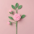 Handmade pink crochet camellia flower branch with green leaves on pink background - Pink