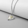 Dettaglio macro di un ciondolo a cuore con scaglie colorate su catena d'argento - Acciaio-Bianco