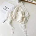 White pastoral lace triangle headscarf with delicate fringe balls in flat lay view - Off White