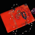 Red cashmere-like scarf with floral embroidery and golden patterns on dark background - Orange