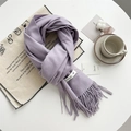 Soft purple cashmere-feel knitted scarf with fringe detail on a cozy lifestyle setup - Coral Purple