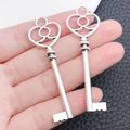 Detailed view of hand-held vintage silver alloy key pendants for DIY jewelry making - Peach Heart Shaped Key (9057)