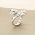 Macro-detail van zilveren wikkelring met ster-stenen en druppelontwerp op een gestructureerd vlak - US 6 / 16mm Staalkleur Dubbele Ster Ingelegde Stijl (KR111168-K)