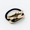 Close-up of elegant gold wavy metal alloy ornament on black elastic hair tie for ponytails - Irregular Double-Layer Wavy (Hair Tie 32)
