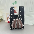 Black knitted tote bag featuring brown pumpkin pattern and white polka dots for autumn - Pumpkin Black