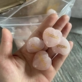 Pink heart-shaped natural crystal stone with golden Gratitude engraving held in hand - Gratitude