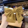 Handcrafted oversized ginger yellow silk satin bow hair clip with elegant glossy finish - Spring Clips / Ginger Yellow