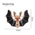Golden bat brooch with black enamel details and red eyes, measures 3.0cm by 4.0cm - Gold Bat