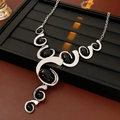 Detail van de zilveren geometrische ketting met zwarte ovalen stenen op een display - Ketting - Zilver