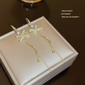 Detail of golden tassel earrings with crystal bow and pearls on a velvet jewelry box - Gold Bowknot Pearl Tassel