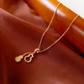 Collier double gourde dorée serti de zircons présenté sur un fond en satin luxueux - Double Gourde en Zircone Dorée (50#)