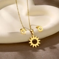 Detail of golden sun pendant necklace and stud earrings set on a heart ceramic tray - Sun (TZ-428)